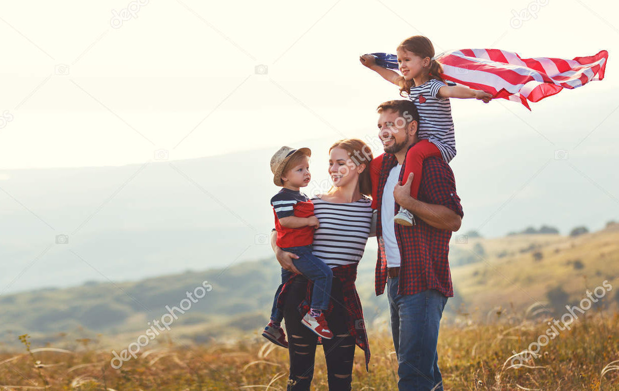 happy family with flag of america USA at sunset outdoors